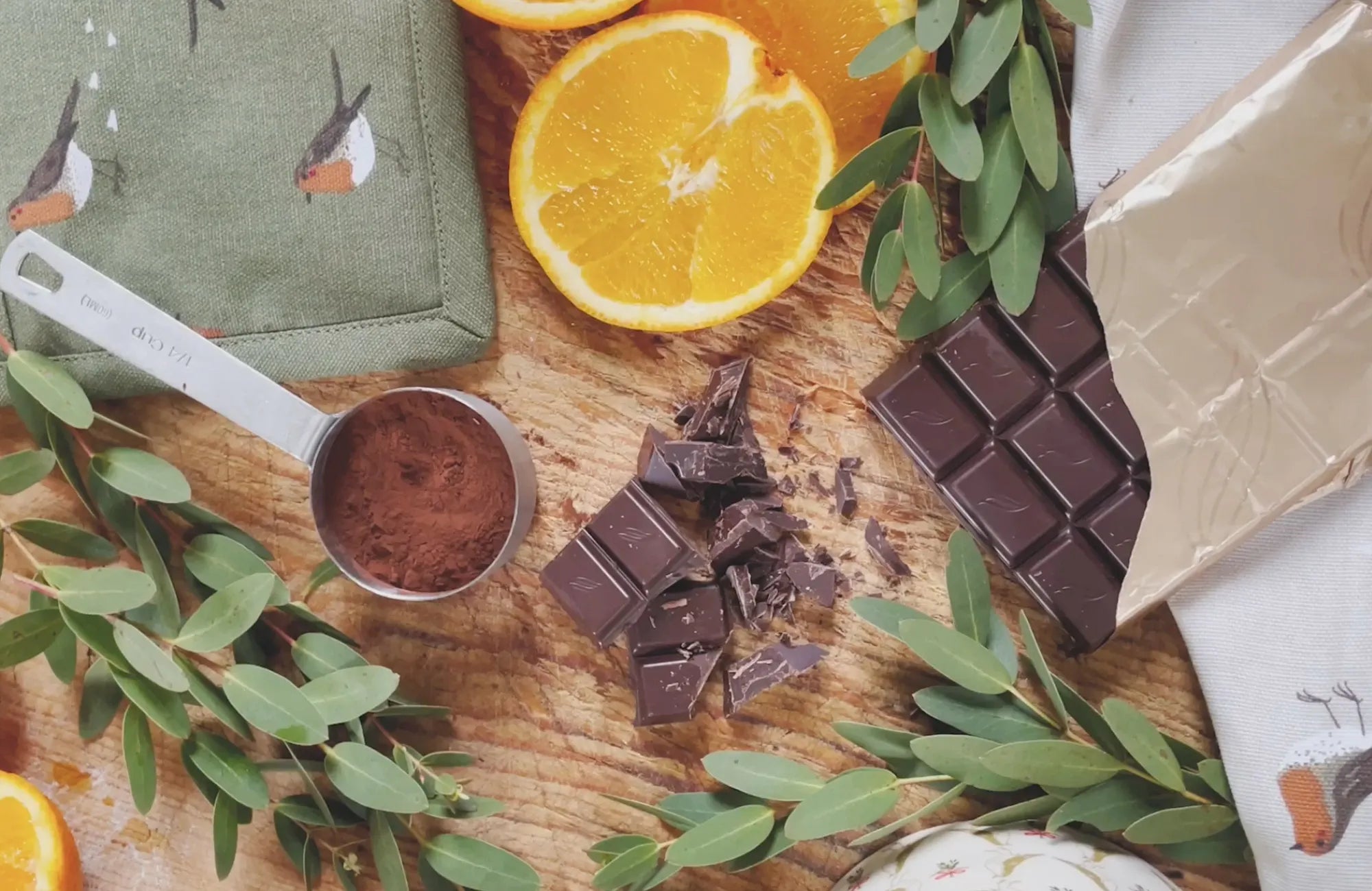 Oranges, chocolate bars, cocoa powder on a work surface