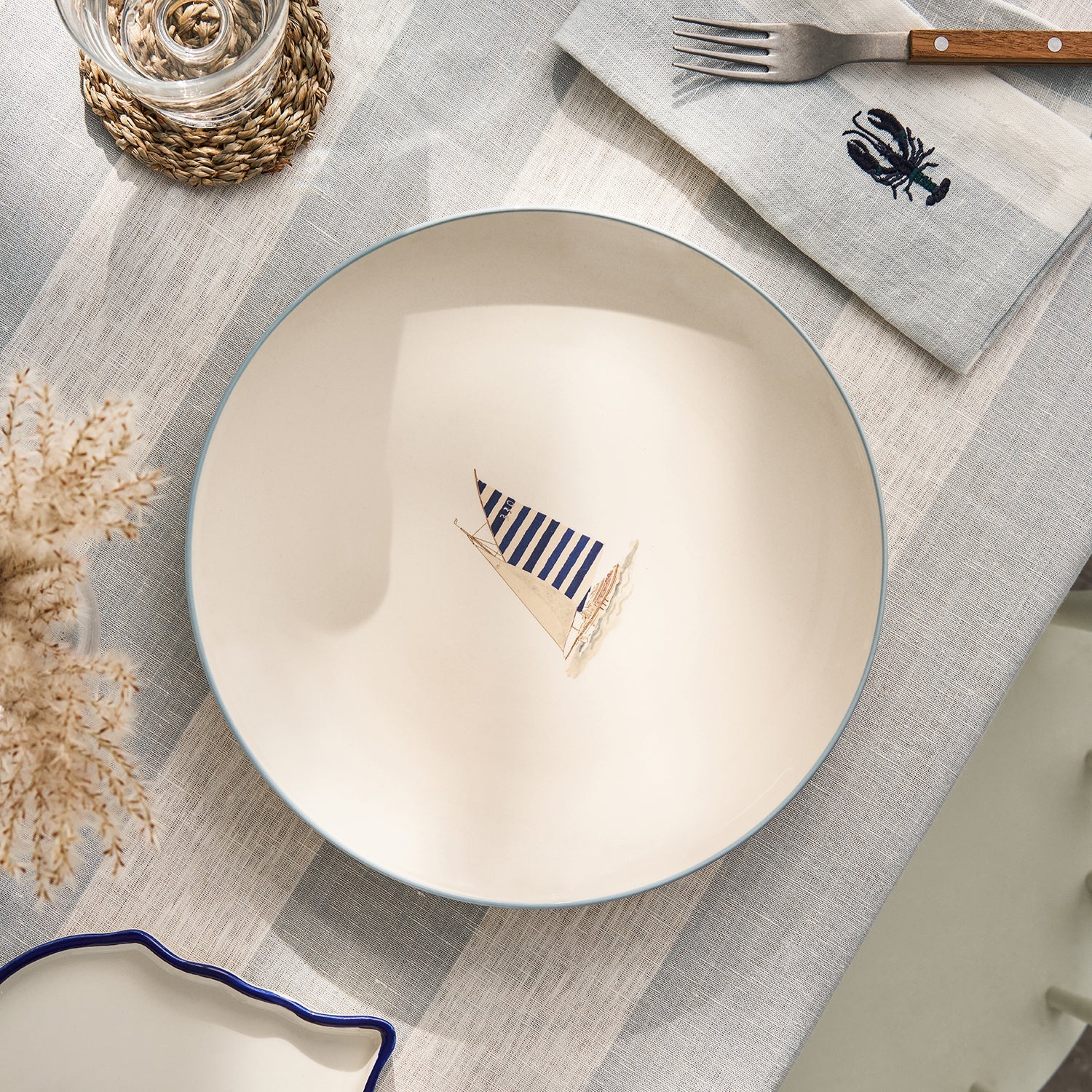 Stoneware dinner plate with blue sailing boat by Sophie Allport