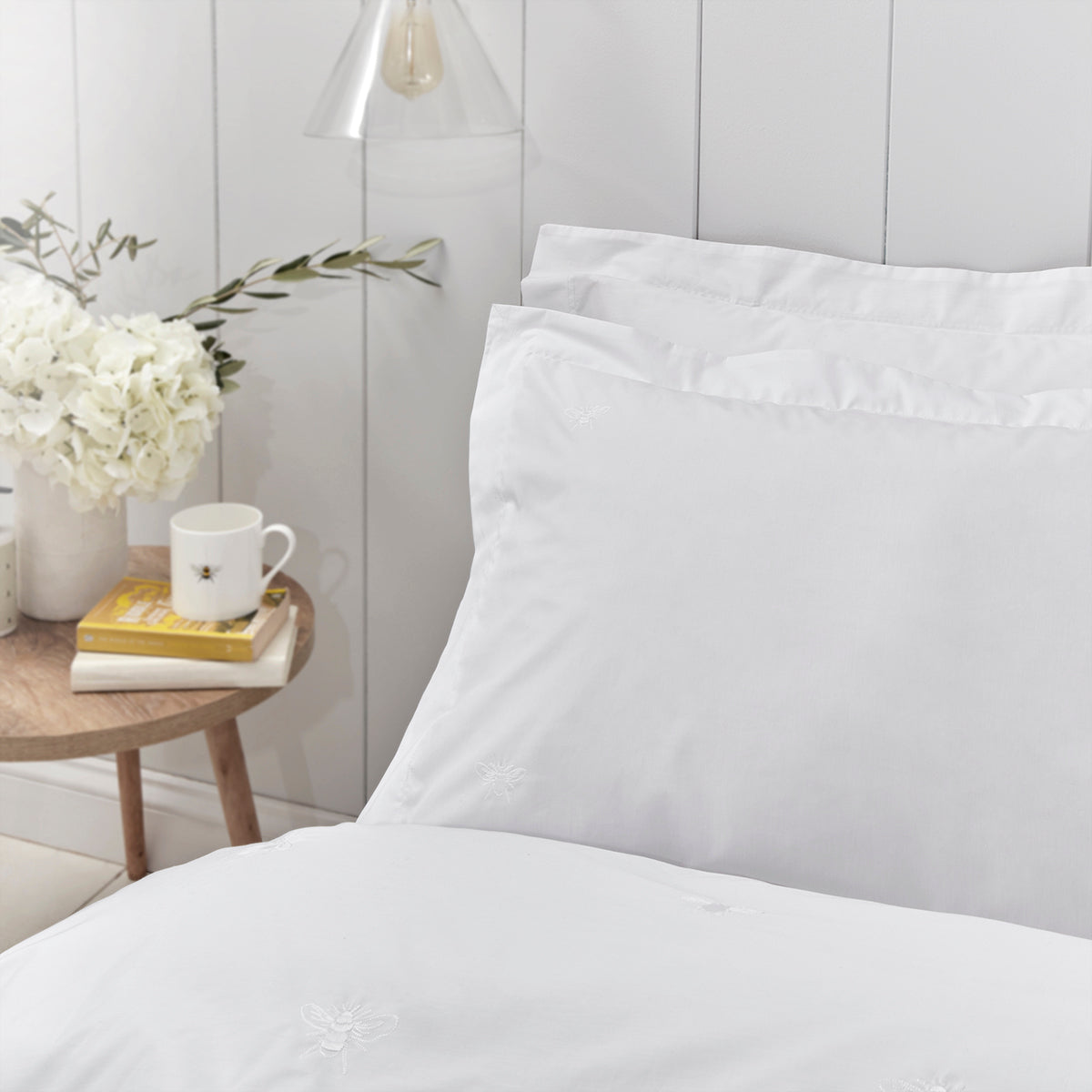 White bedding with embroidered bee detailing by Sophie Allport