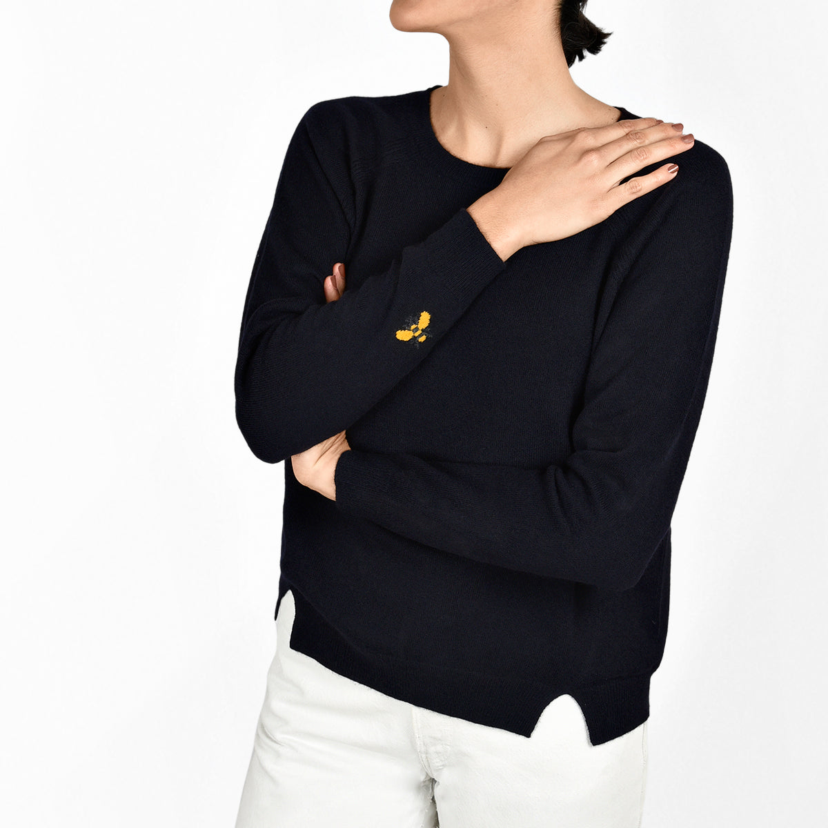 Model wearing cashmere jumper with bee detailing