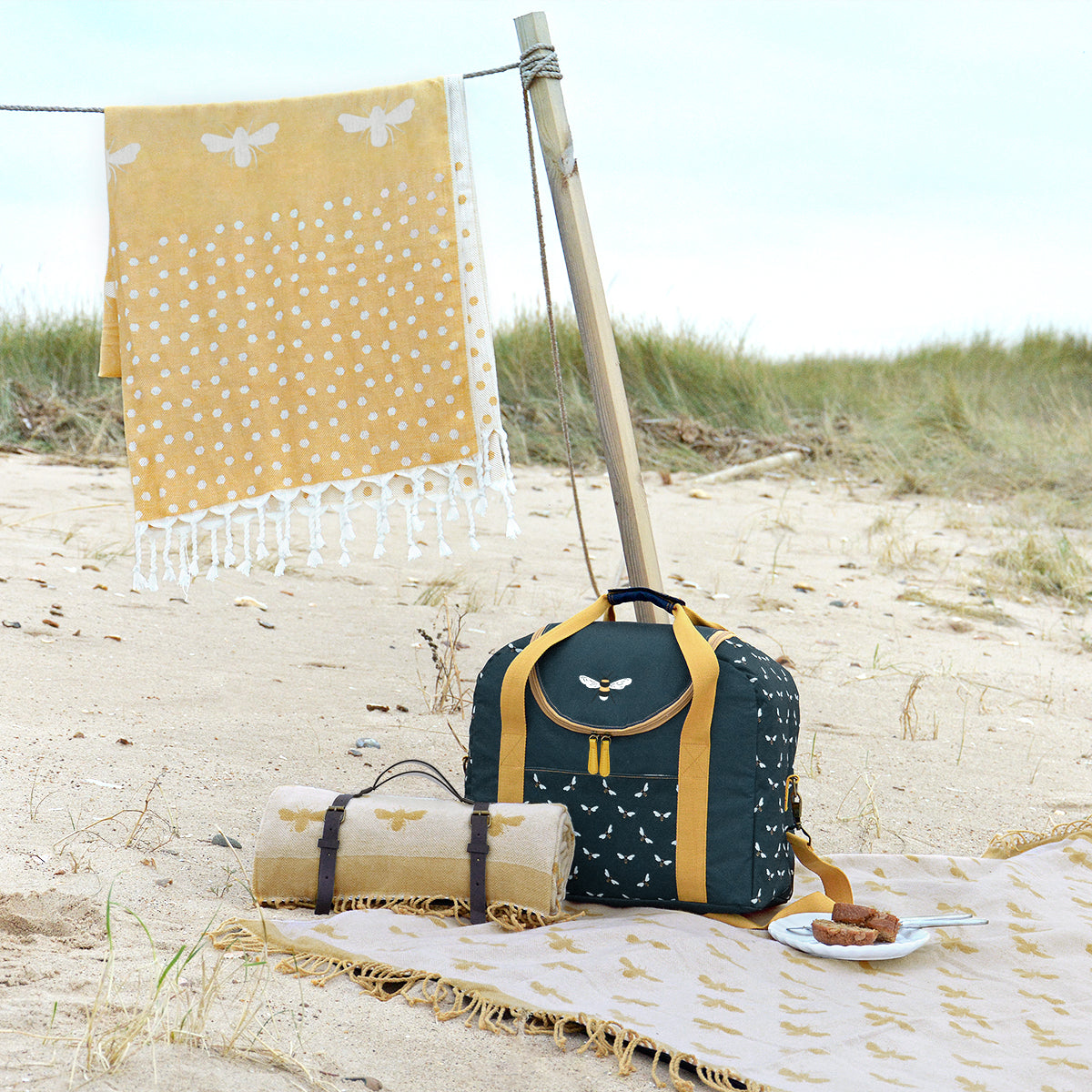 Yellow picnic blanket covered in Sophie Allport's bees picnic collection.