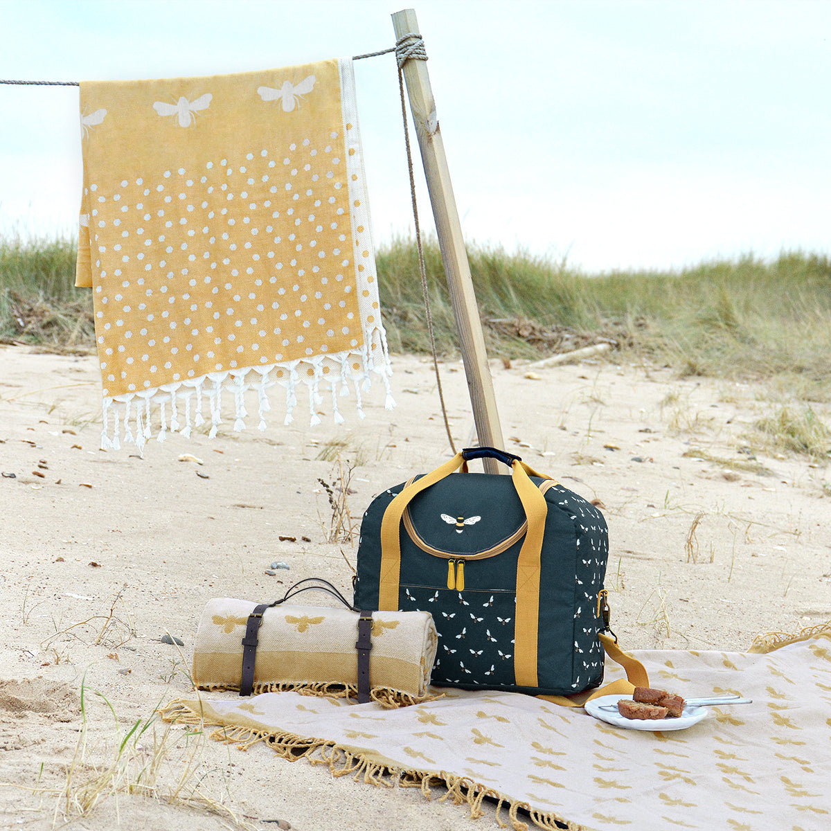 Sophie Allport's yellow hammam towel covered white bees, perfect for the park or beach.