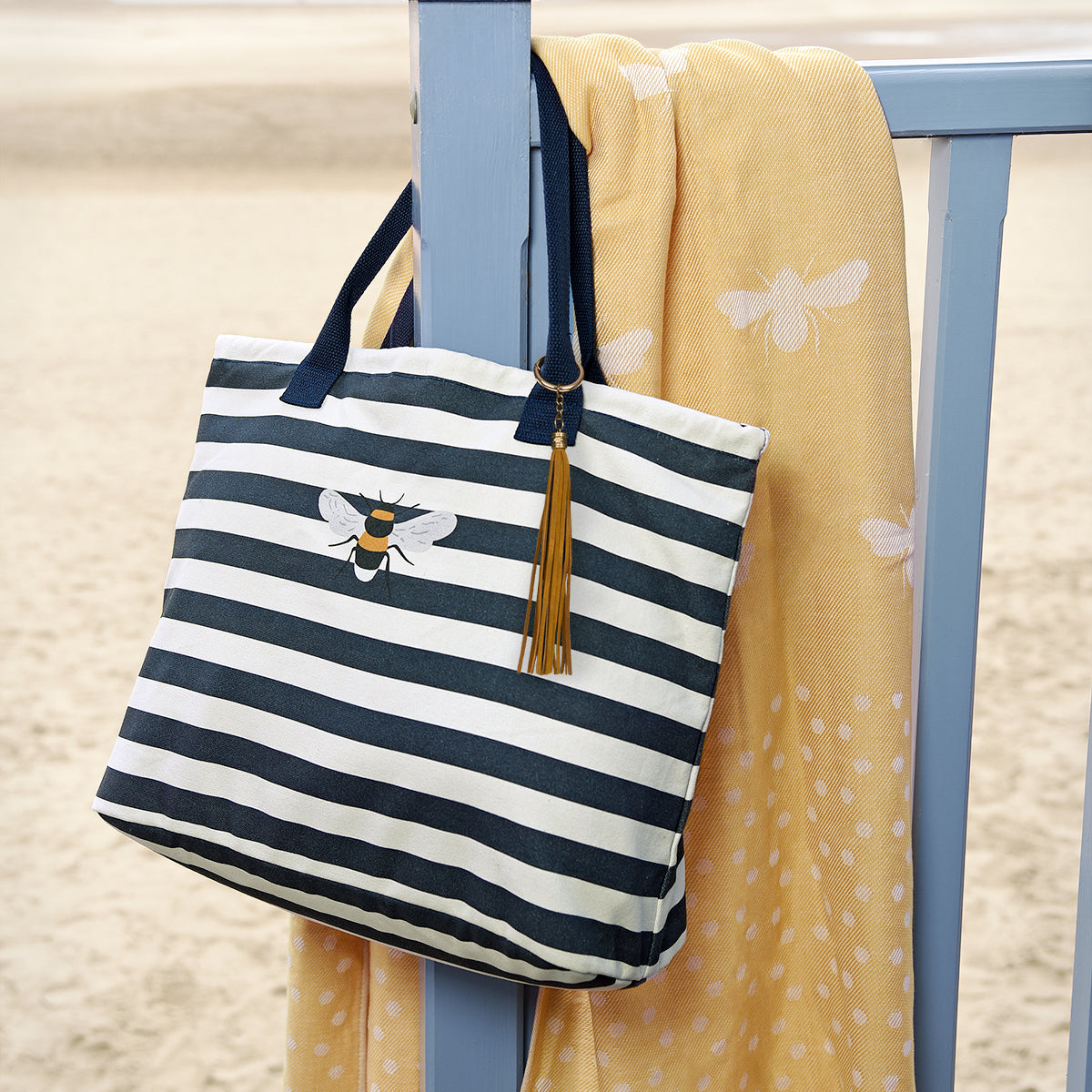Sophie Allport's yellow hammam towel covered white bees slung over a beach hut post.